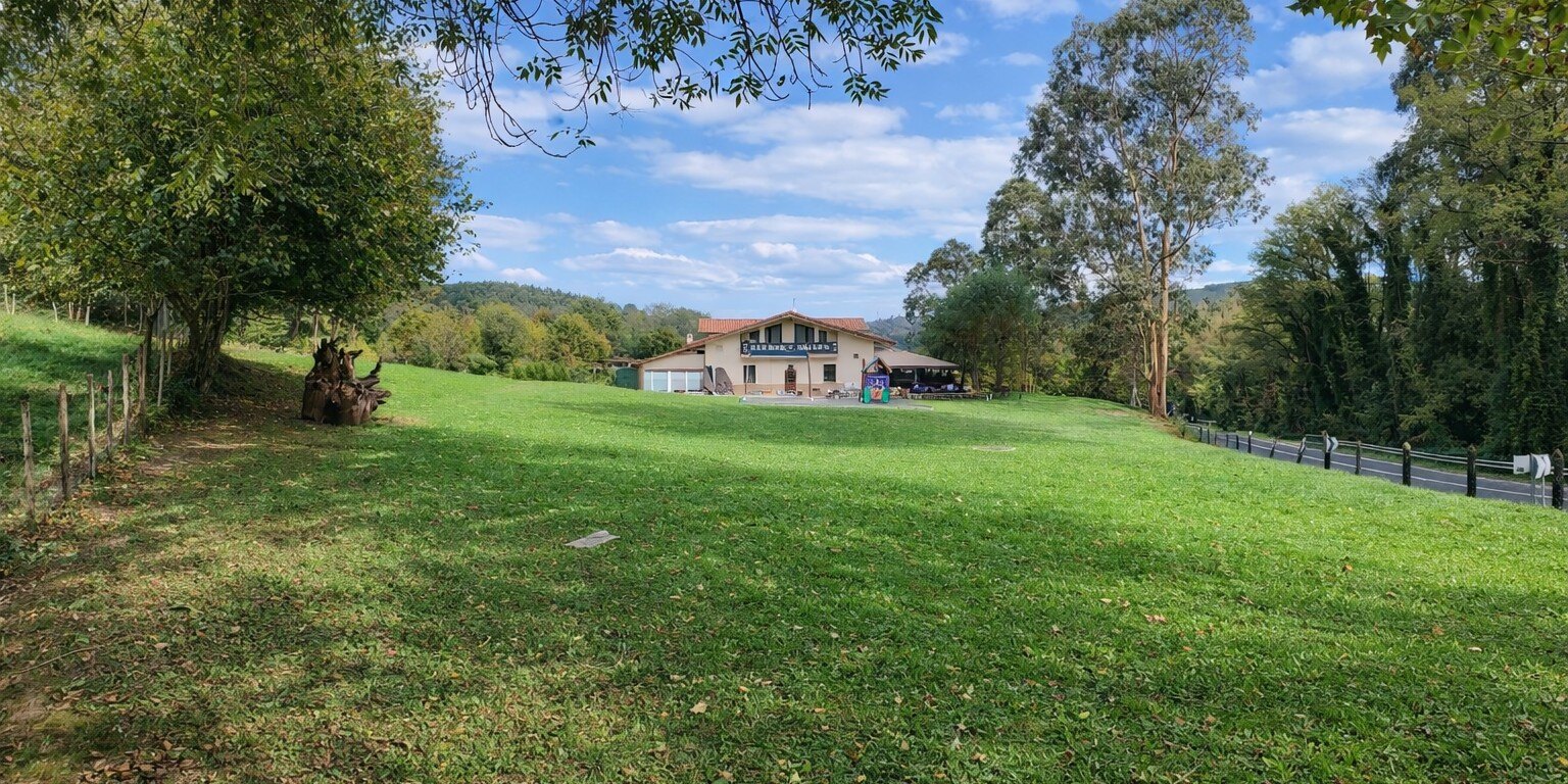 Campa y entorno verde alrededor del Asador Urizar